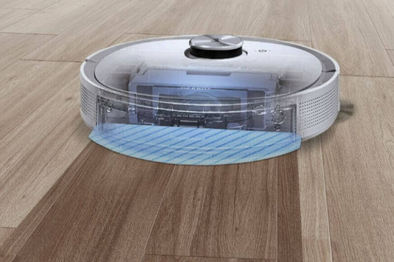 Wassertank und mobiler Staubbehälter liegen hinter einem Saug-Wisch-Roboter